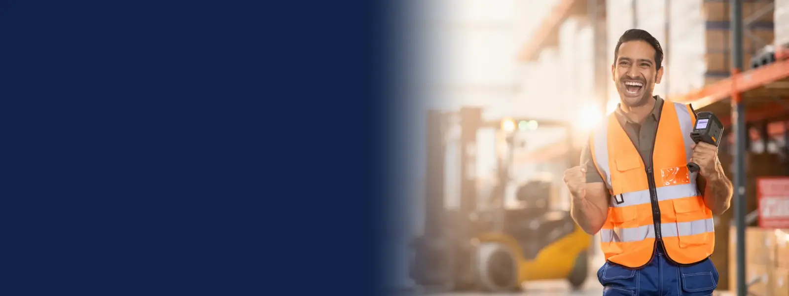 Warehouse worker with an rf scanner celebrating in a distribution centre