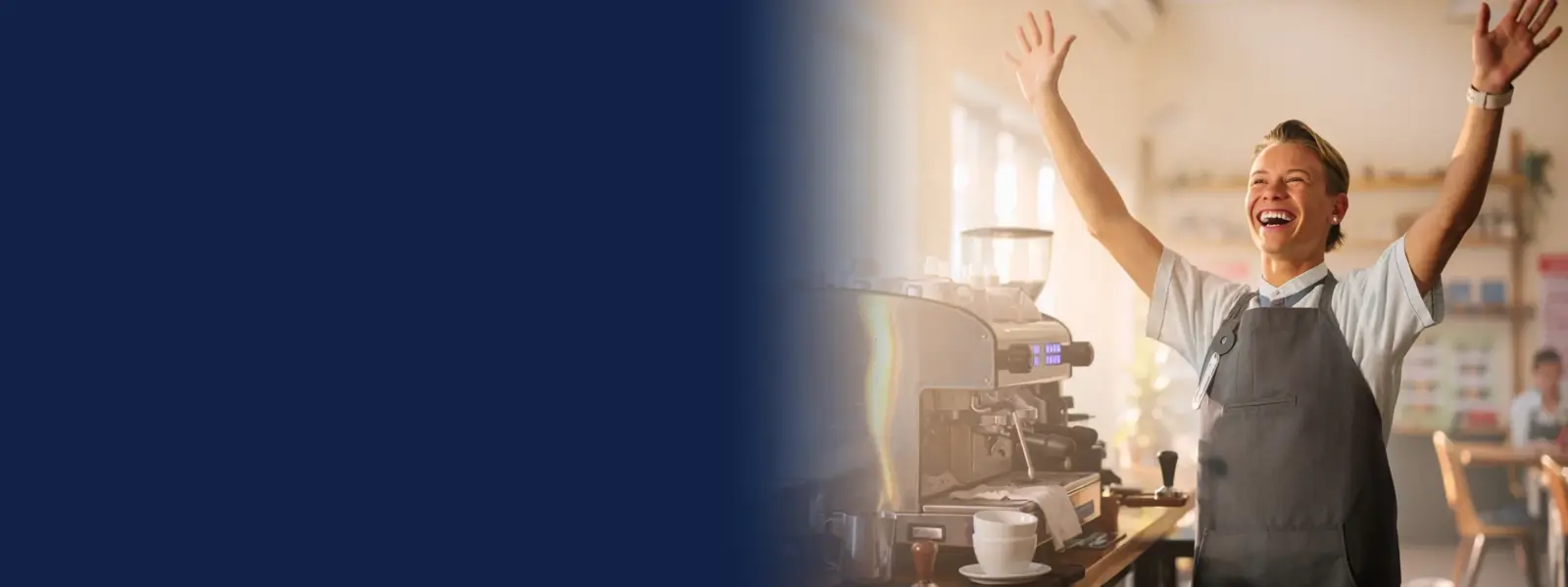 Student barista celebrating behind an espresso machine